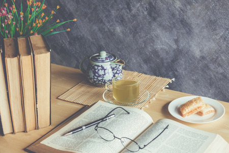 Still life tea time with cup of green tea and  books on tableの写真素材