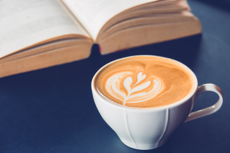cup of latte or cappuccino coffee with a book in coffee shopの写真素材