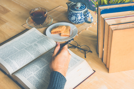 A man reading books and drinking teaの写真素材