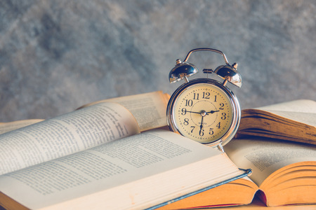 Vintage alarm clock on stack old booksの写真素材
