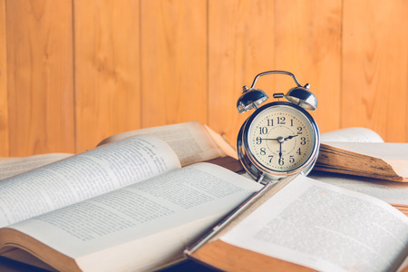 Vintage alarm clock on stack old booksの写真素材