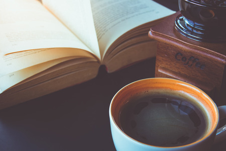 A cup of black coffee with book on tableの写真素材