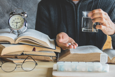 Education and health concept,A man hard study and reading, he headachesの写真素材