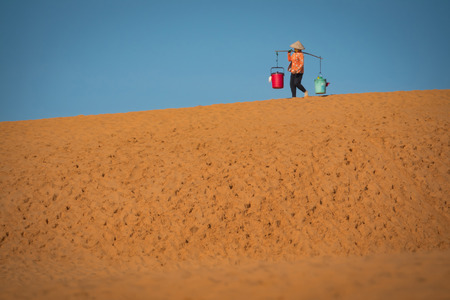 Vietnamese lady caring a Yoke shop on Red Sand Dune , Mui Neの写真素材