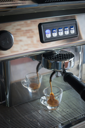 Professional espresso machine pouring strong looking fresh coffeeの写真素材