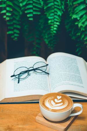 Cup of latte or cappuccino coffee with a bookの写真素材