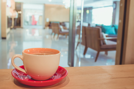 Coffee cup on table with Blurred seats in Restaurant shop cafe Interiorの写真素材