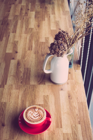 Coffee latte art on wooden table in coffee shopの写真素材