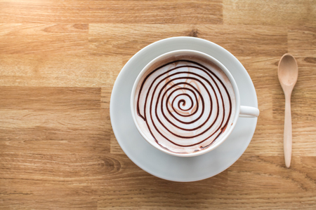 Hot chocolate spiral design on wood table with space for wordingの写真素材