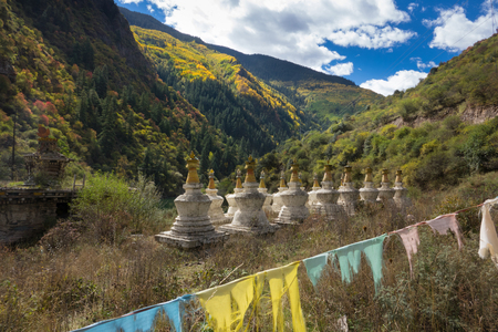Holy pagodas in Tibetan temple with colorful forest on mountainの写真素材
