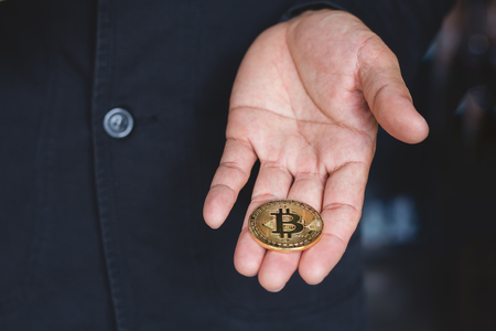 Businessman hand Money holding golden Bitcoinの写真素材