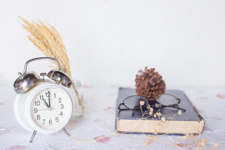 Vintage story , bell clock  on old book with eyeglassesの写真素材