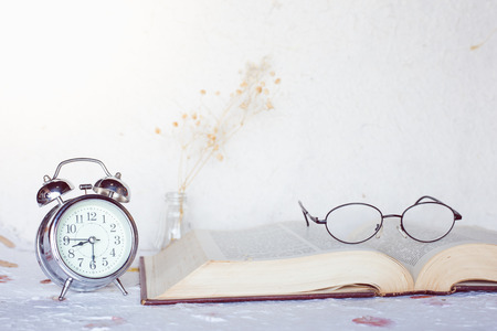Vintage story , bell clock and eyeglass on old bookの写真素材