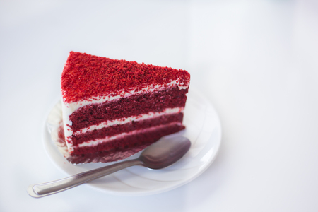 Red velvet cake on white dish with spoon on white backgroundの写真素材