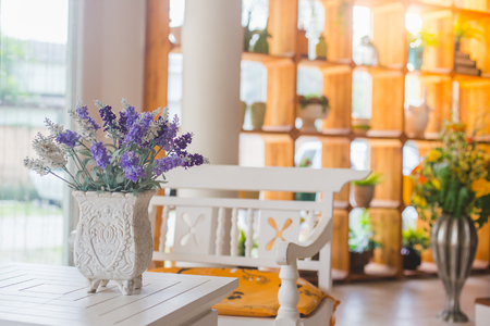 Bautiful purple flower in vintage flower pot on white table with sun lighting from windowの写真素材