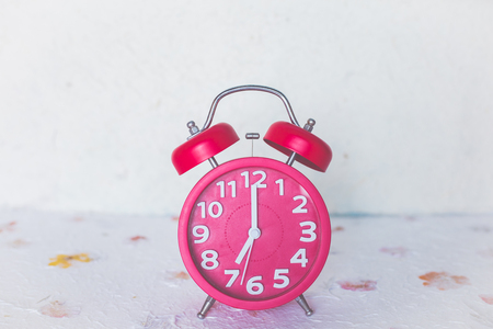 Red alarm clock on leaf ground with soft filter imageの写真素材
