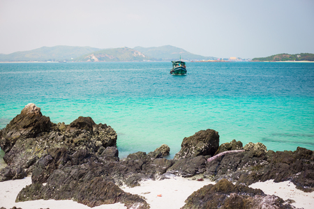 Lonely boat on sea with island backgroundの写真素材