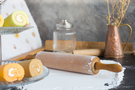 Rolling pin and white flour with bakery on glassの写真素材