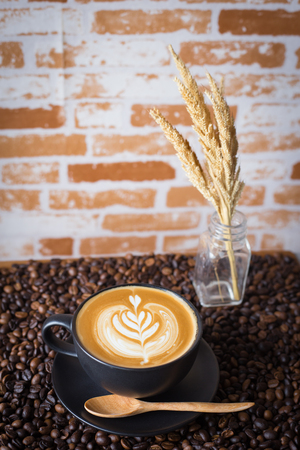 Latte art coffee above at coffee beans backgroundの写真素材