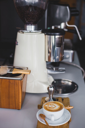 A cup of  coffee on wood  at espresso bar with coffee machineの写真素材
