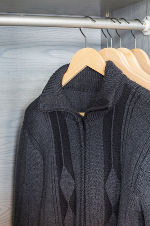 A hanger with things. Knitted sweaters hang on hangers. Bright sweaters. Spring clothes.の写真素材