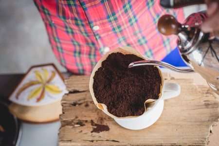 Hand drip coffee , Barista pouring water on coffee ground with filterの写真素材