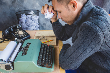 A man had mistake of work with typewriter he must new type again ,  bin backgruond has many mistake paperの写真素材