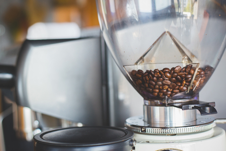 Coffee beans in coffee grinder with sun lighting in cafeの写真素材