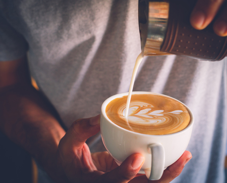 Barista pouring milk to coffee. Latte art. How to make  coffee latteの写真素材