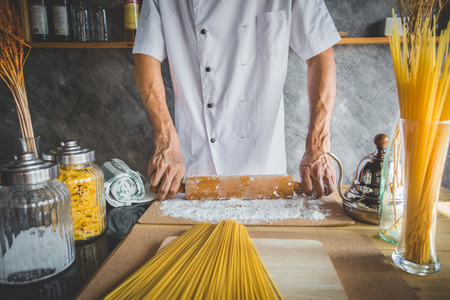 Chef use rolling pin with flour on cooking table wiht accessories on kitchenの写真素材