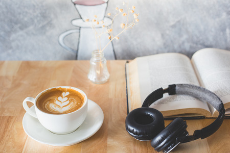A cup of latte coffee, book and headphone on a wooden floor. Time to relax.の写真素材