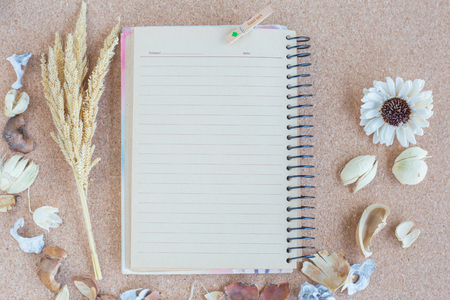 Notebook with dried flower frame on wood texture backgroundの写真素材