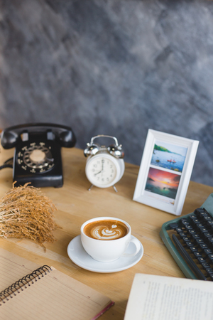 A cup of coffee latee on white cup on working tableの写真素材