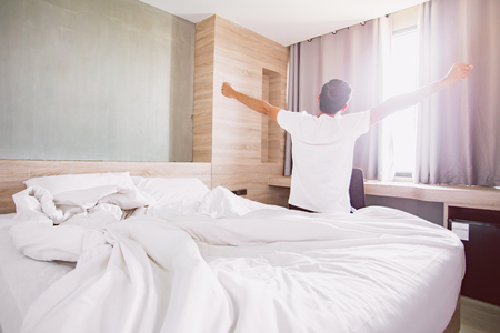 Morning of a new day, alarm clock waking up man stretch the muscles at window , . Health conceptの写真素材