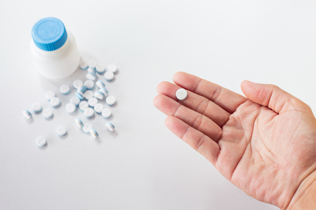 pills and medicines in the hand with medicines and pill on  groundの写真素材