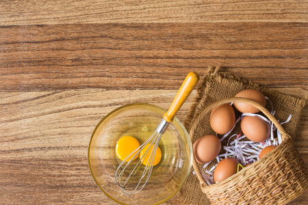 Raw egge with fresh egg on small bowl with  egg whisk on concrete background , kitchen concept with blank space for your textの写真素材