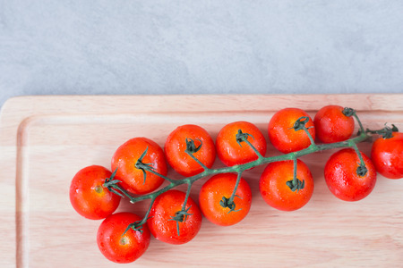 Cherry tomatoes  on cutting board over concreat table background , flat lay image with copy space for your textの写真素材