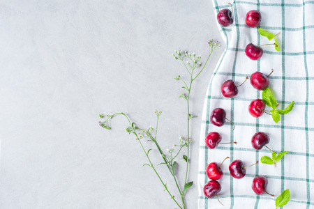 Cherries on a white cloth with flower , flat lay image with copy space for your textの写真素材