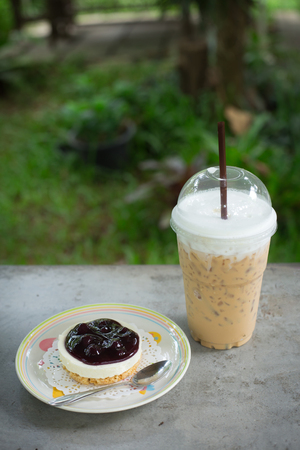 ice coffee take away and cake on concrete tableの写真素材