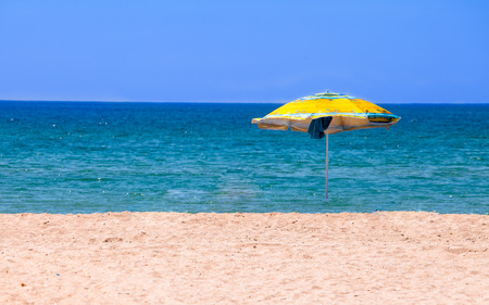 Deserted beach with umbrellaの写真素材