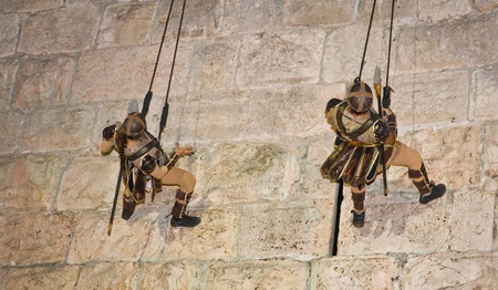 JERUSALEM - NOV 03 : An Israeli acrobats dressed as knight climbing on the old city walls in the...