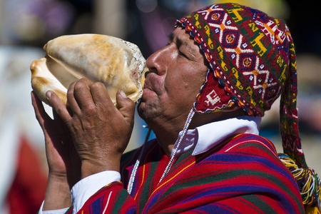 CHINCHERO , PERU - MAY 29 2011 : An unidentified Peruvian man with traditional clothes blowing a...