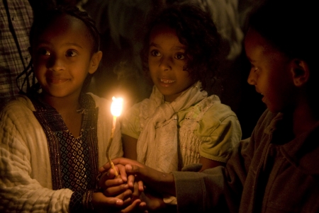 JERUSALEM - APRIL 14 : Ethiopian Orthodox children hold candele during the Holy fire ceremony at the Ethiopian section of the Holy Sepulcher in Jerusalm Israel on April 14 2012のeditorial素材