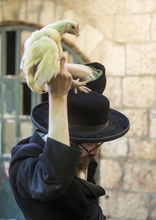 JERUSALEM - SEP 25 : An ultra Orthodox Jewish man waves a chicken over his head during the Kaparot ceremony held in Jerusalem Israel in September 25 2012 のeditorial素材