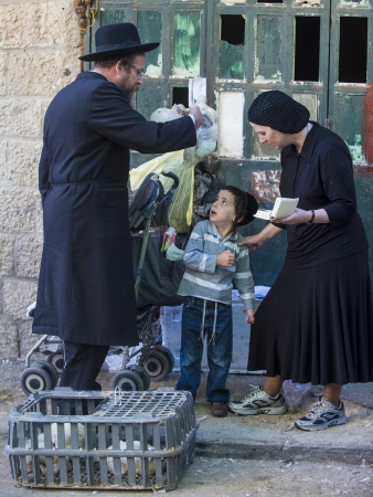 JERUSALEM - SEP 25 : An ultra Orthodox Jewish man waves a chicken over his child's heads during the Kaparot ceremony held in Jerusalem Israel in September 25 2012のeditorial素材