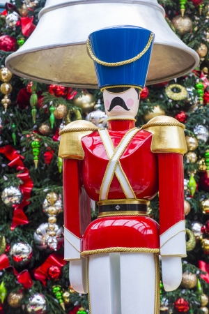 close up on a wooden nutcracker with a background of christmas tree and ornamentsの写真素材