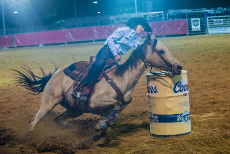 LOGANDALE , NEVADA - APRIL 10 : Cowgirl Participating in a Barrel racing competition in the Clark County Fair and Rodeo a Professional Rodeo held in Logandale Nevada , USA on April 10 2014のeditorial素材