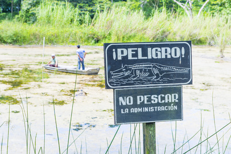 TIKAL , GUATEMALA - JULY 29 : Crocodile warning sign near an artificial pond in Tikal Guatemala's national park on July 29 2015 The pond was created by the Mayans For collecting rainwaterのeditorial素材