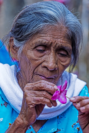 PANCHIMALCO , EL SALVADOR - MAY 08 : A Salvadoran woman decorates palm fronds with flowers during the Flower & Palm Festival in Panchimalco, El Salvador on May 08 2016のeditorial素材
