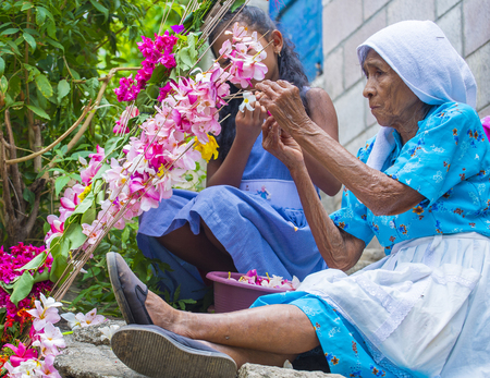 PANCHIMALCO , EL SALVADOR - MAY 08 : A Salvadoran woman decorates palm fronds with flowers during the Flower & Palm Festival in Panchimalco, El Salvador on May 08 2016のeditorial素材